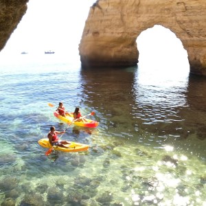 a group of people on a rock in the water
