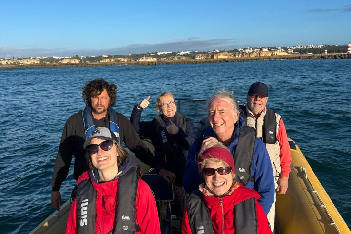 a group of people standing next to a body of water